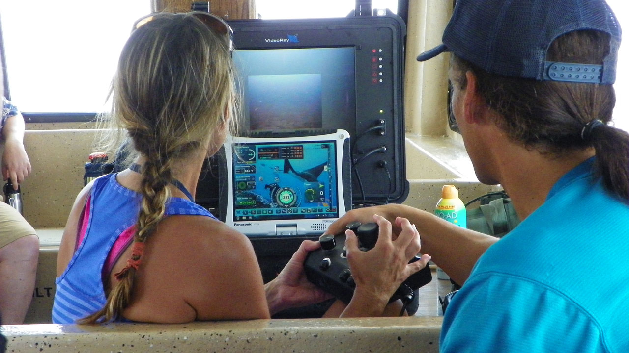 Two educators learn to drive an ROV.