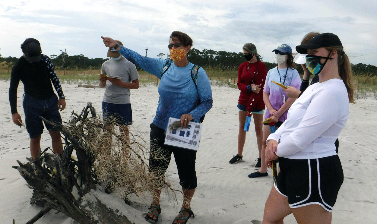 Discovery Hall Programs marine educator points towards the Gulf during high school marine science class.