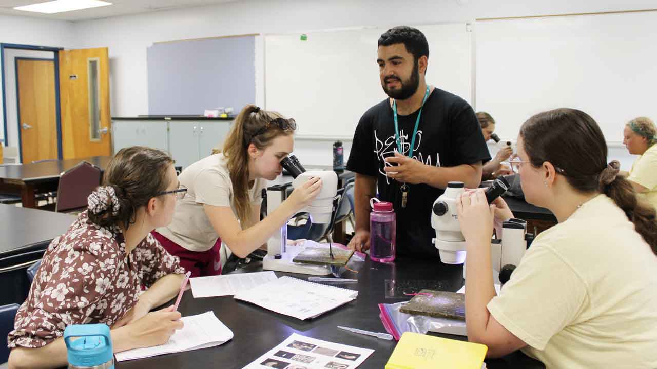 undergraduates get tips during ecology lab